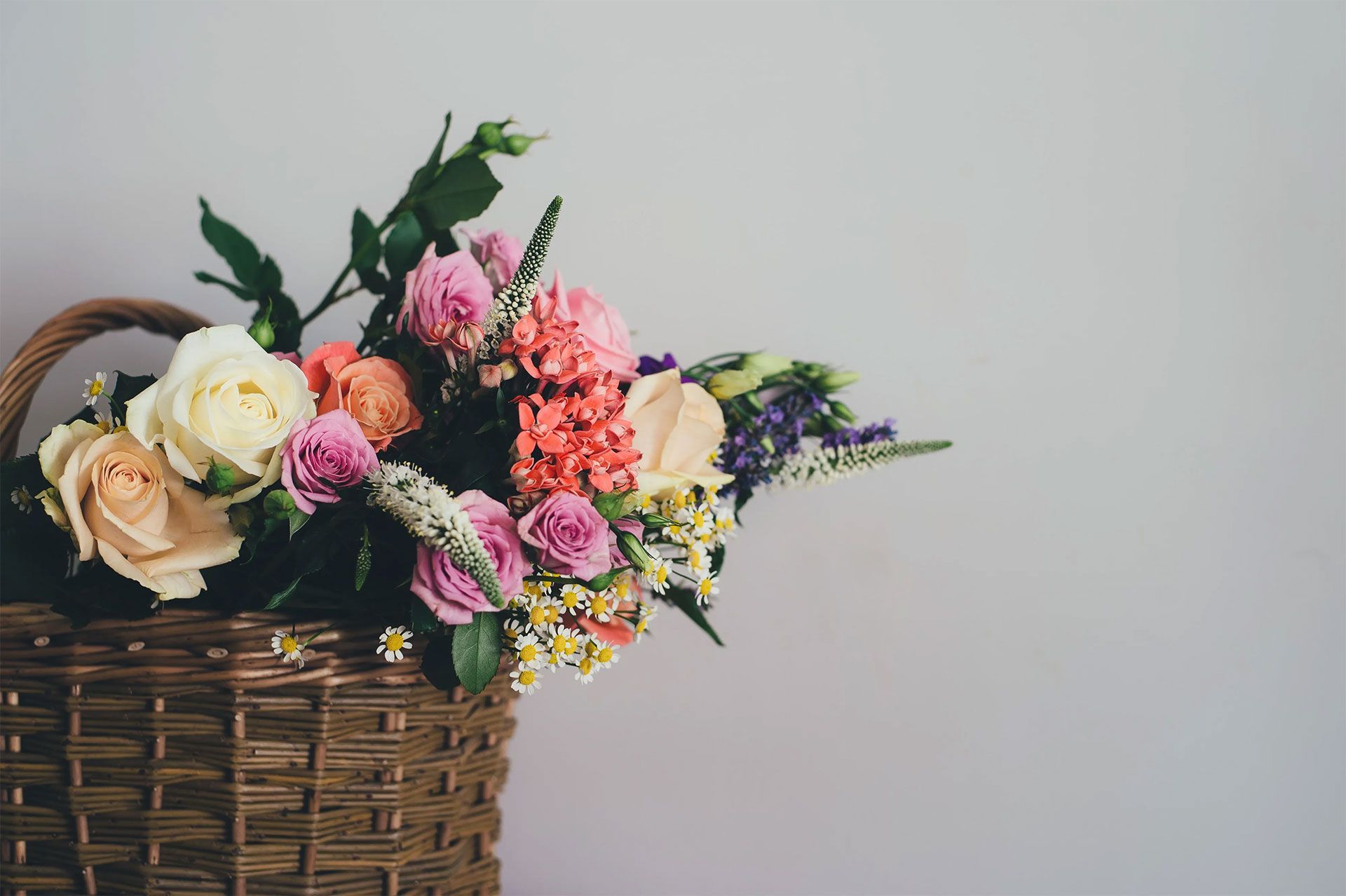 A basket filled with flowers is sitting on a table.