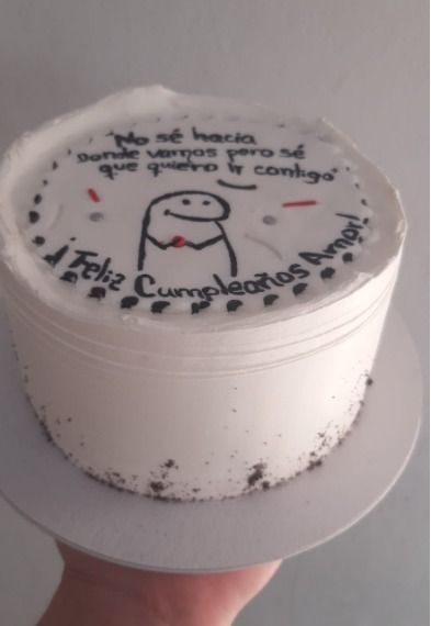 Pastel glaseado blanco con texto negro y una figura de palitos que dice: 