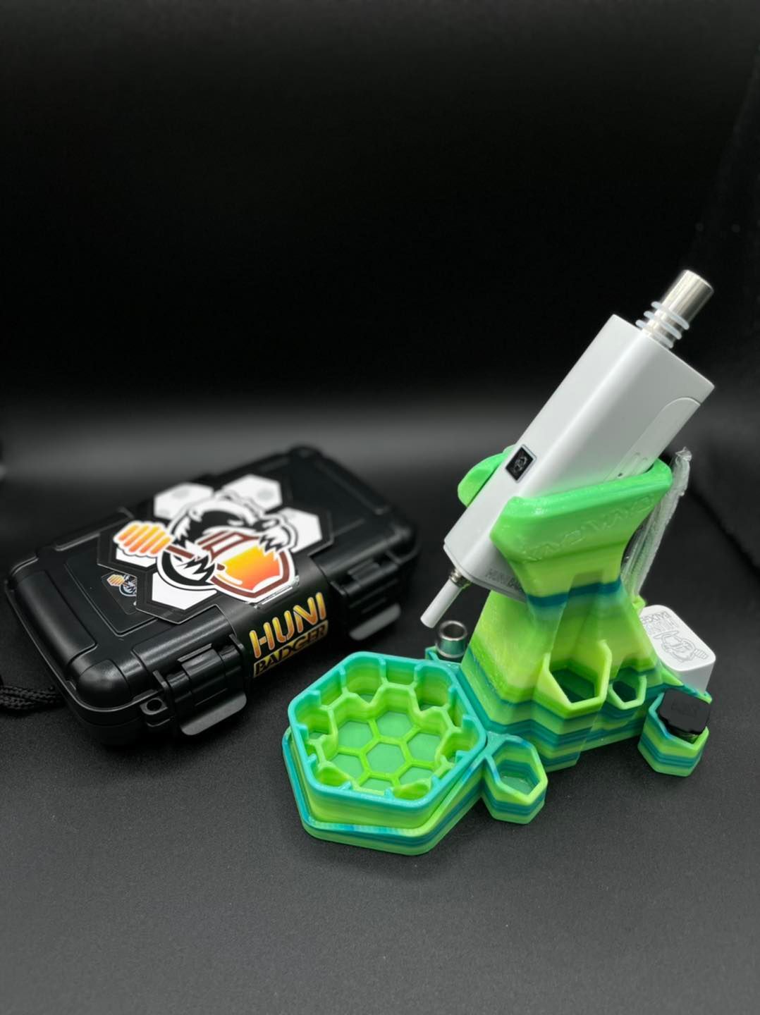 A green and white device is sitting next to a black case.