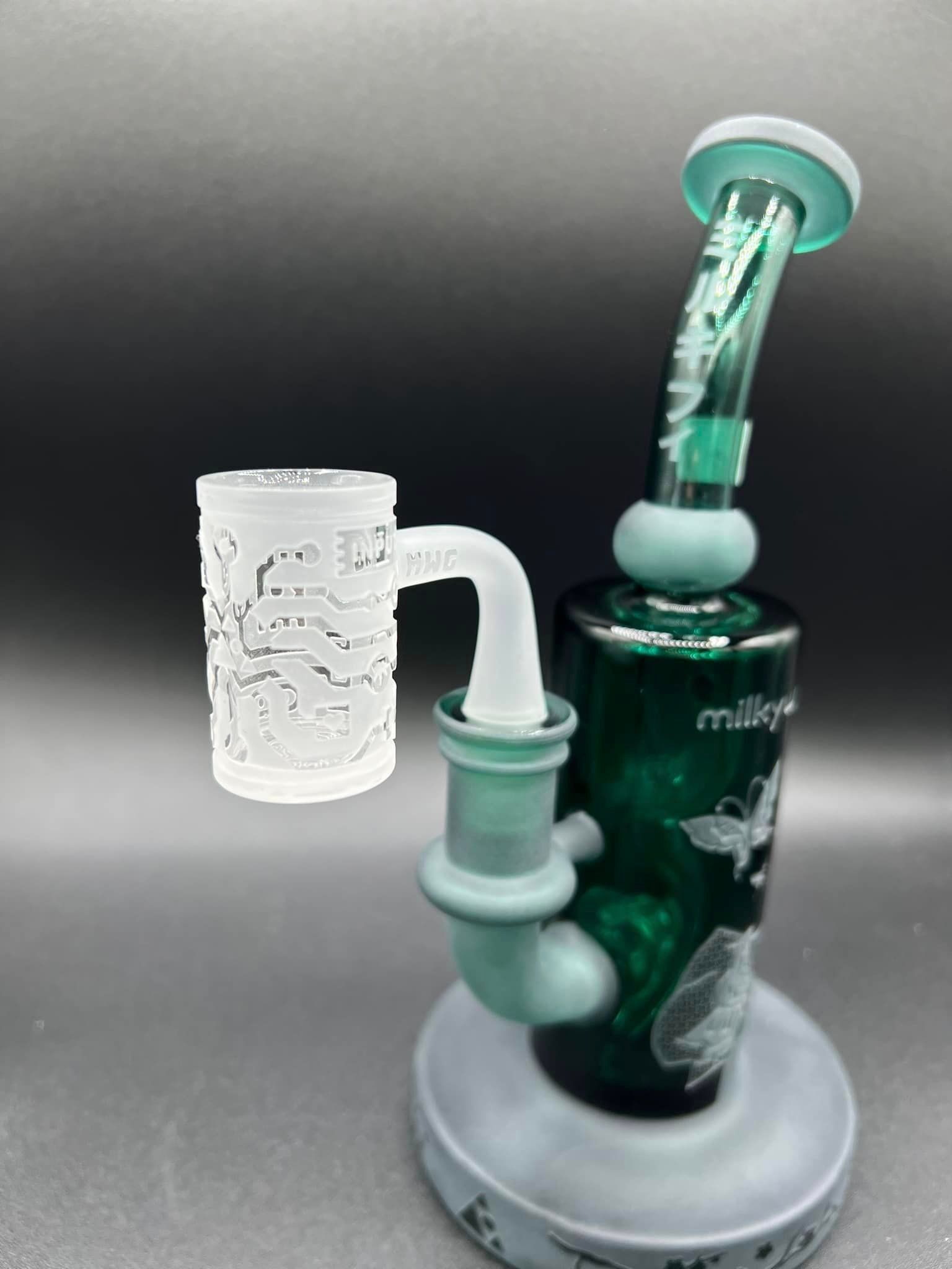 A green glass bong with a white cup on top of it.