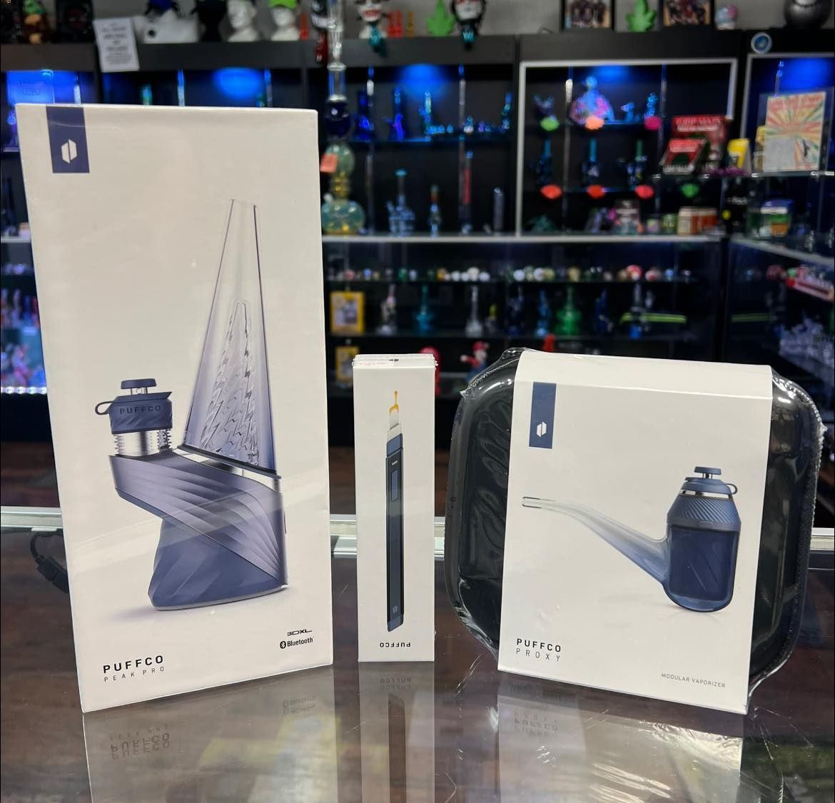 Three boxes are sitting on a glass table in a store.