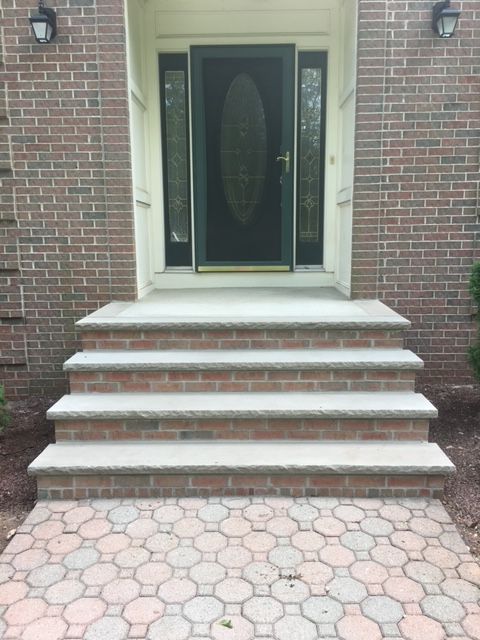 A brick house with stairs leading up to the front door