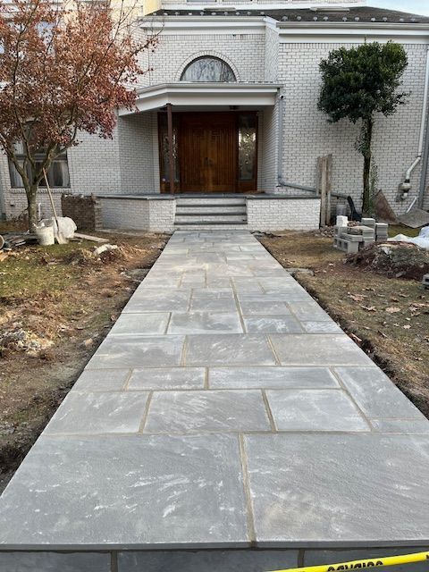 A concrete walkway is being built in front of a house.