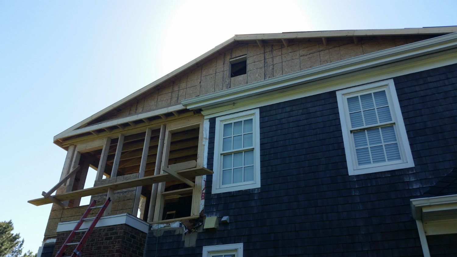 A house is being built with a ladder in front of it.
