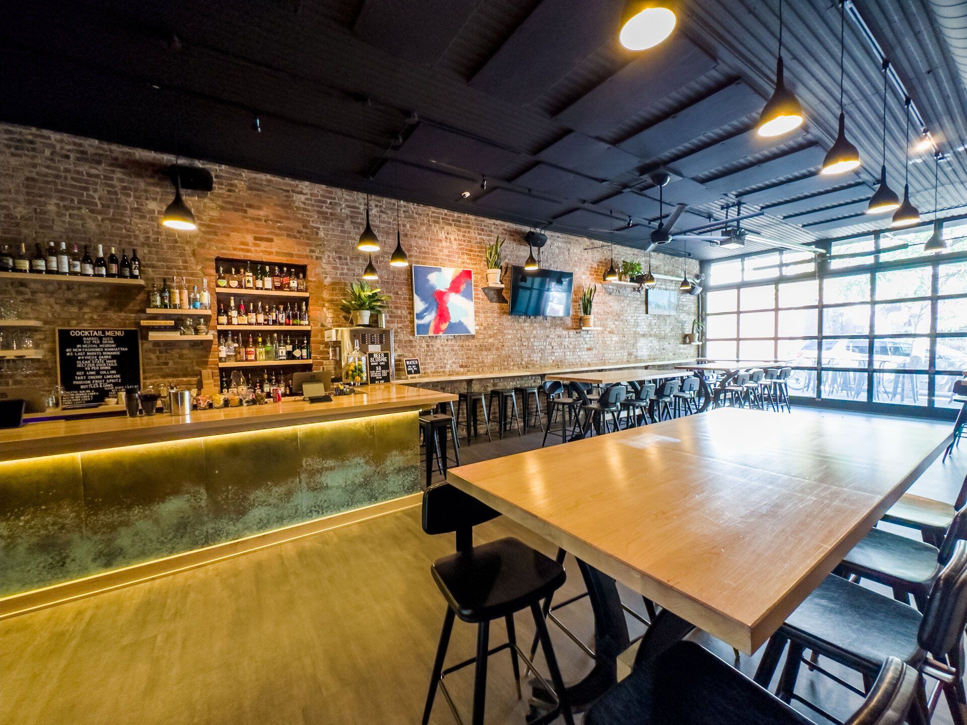 A restaurant with tables and chairs and a bar.