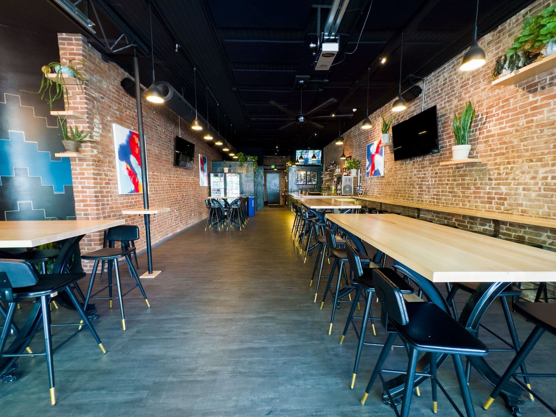 A long hallway with tables and chairs in a restaurant.