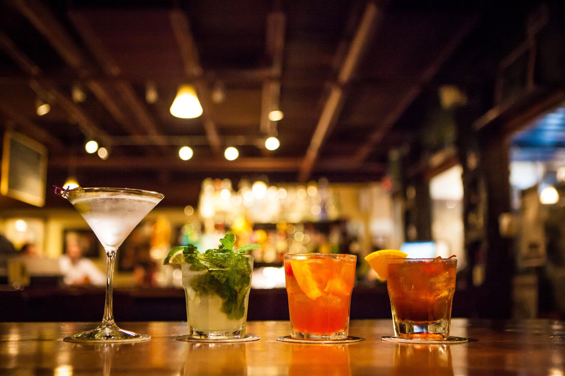 Three different types of drinks are sitting on a bar.