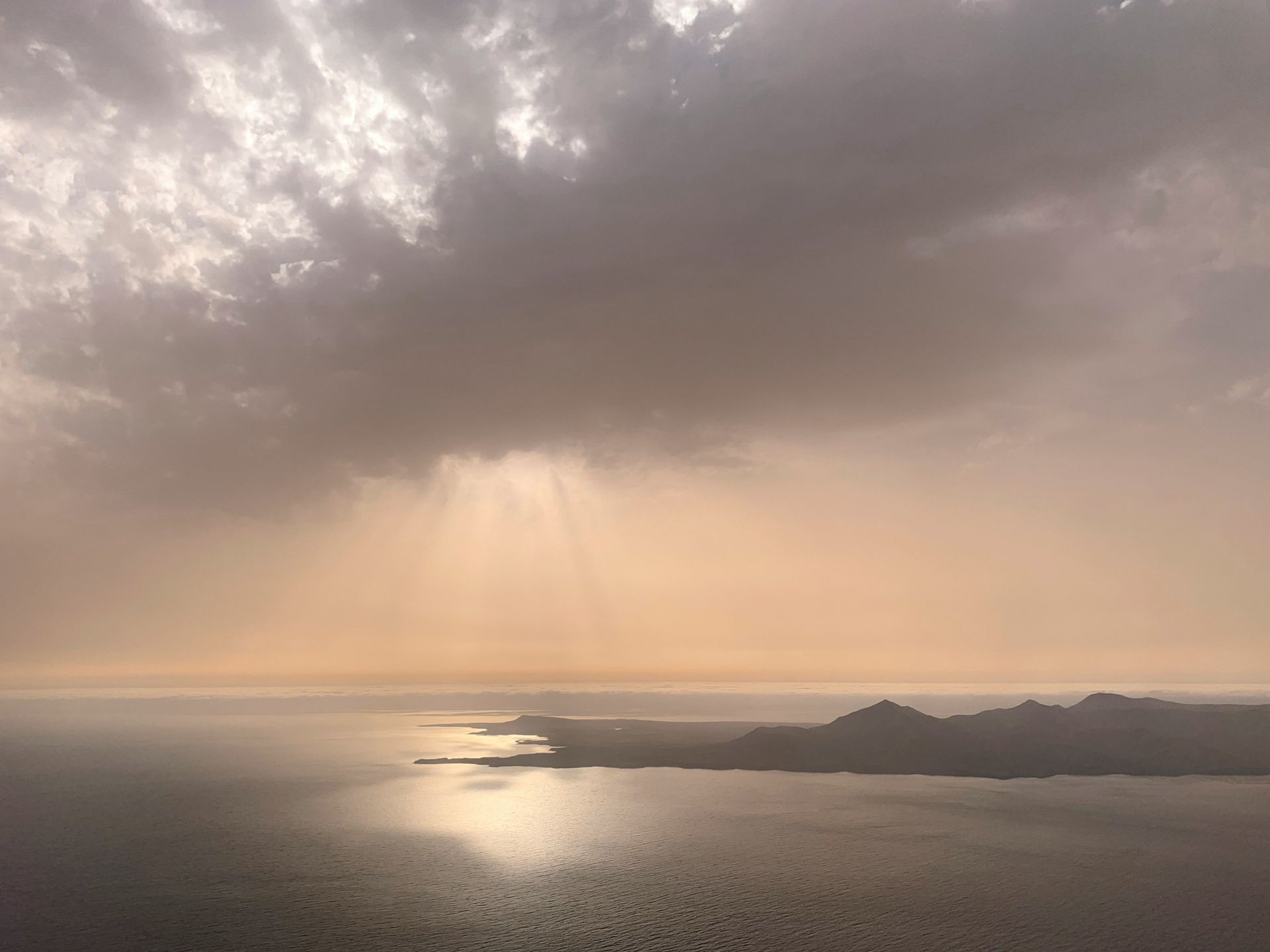 Sun rays breaking through clouds over sea