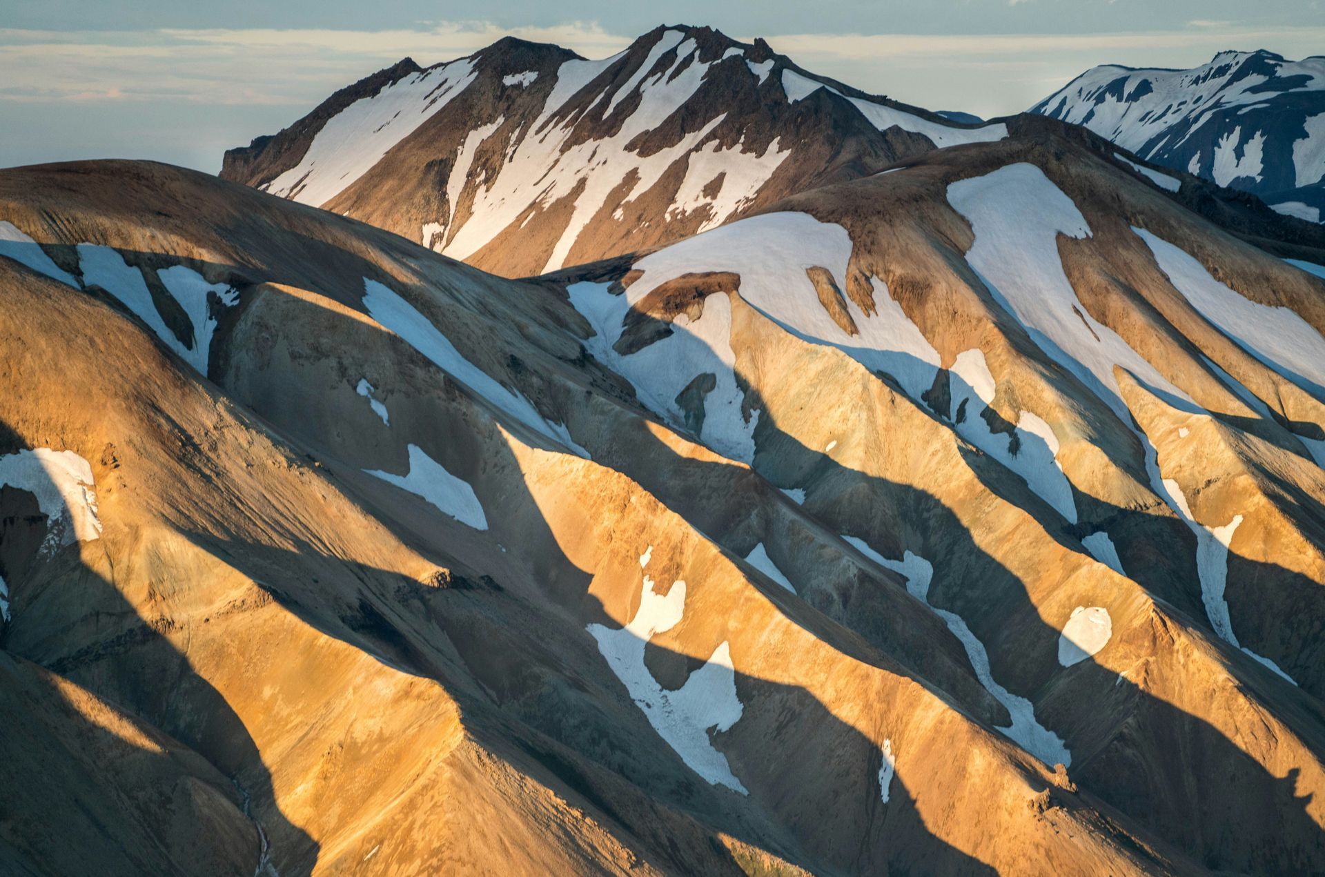 Sunlit mountains with snow patches, symbolizing resilience and clarity during challenges.