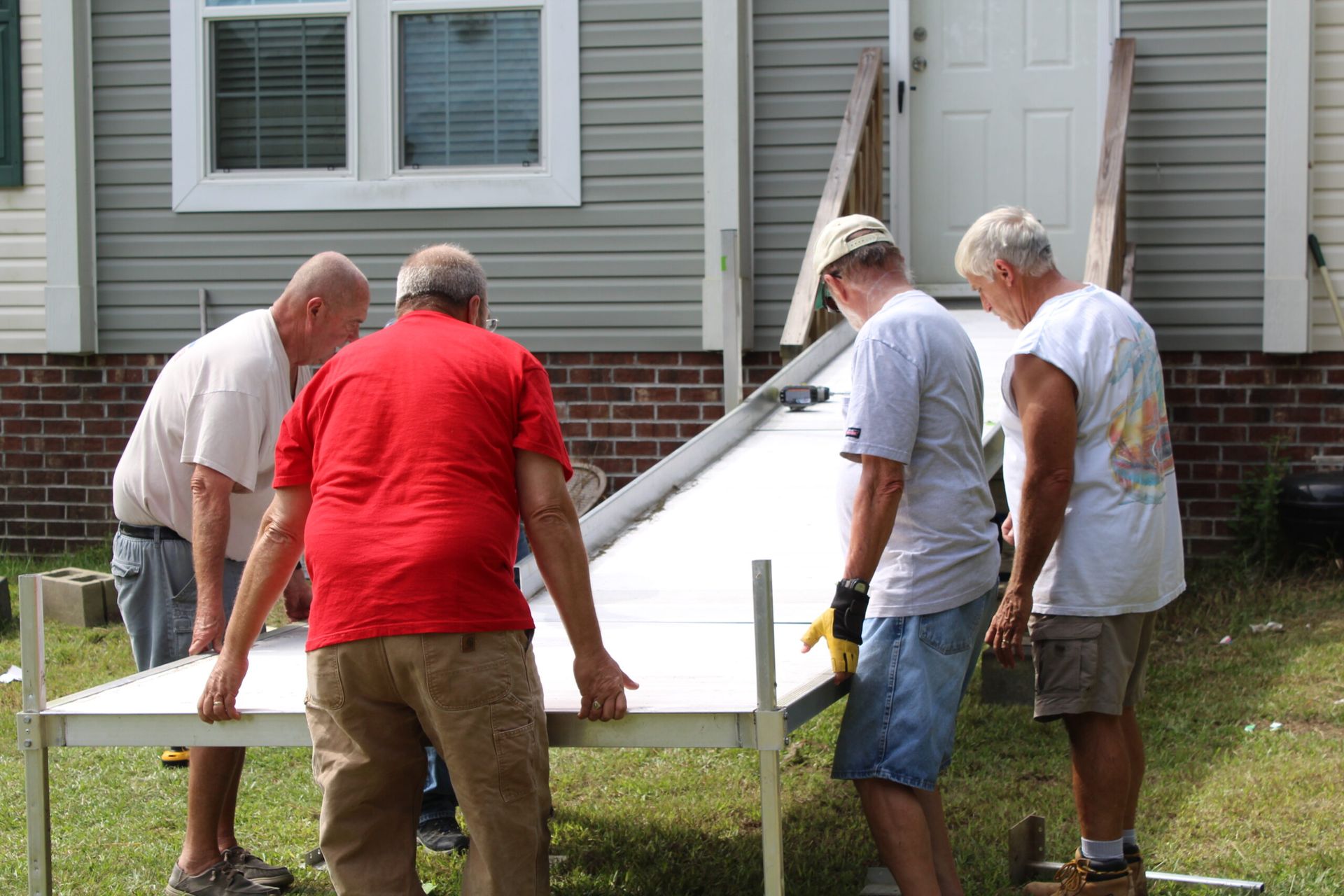 Sunset over water with a bright orange sky. Silhouette of land on the left, posts in the water.