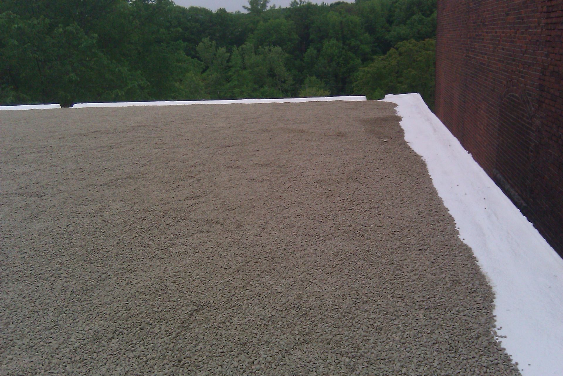 A roof with a white border and gravel on it