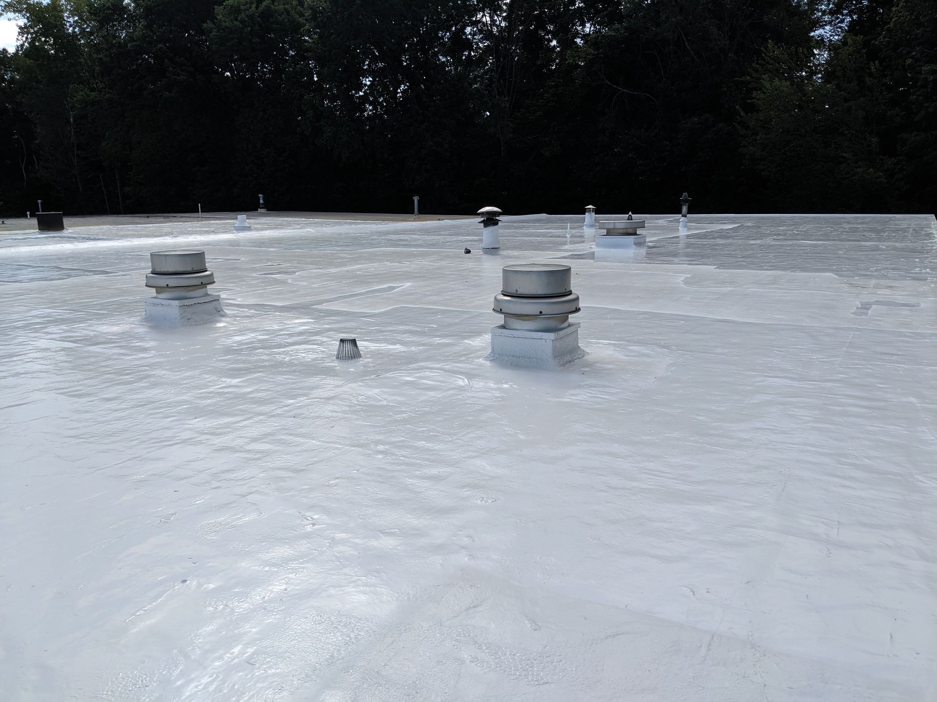 A white roof with a lot of vents on it