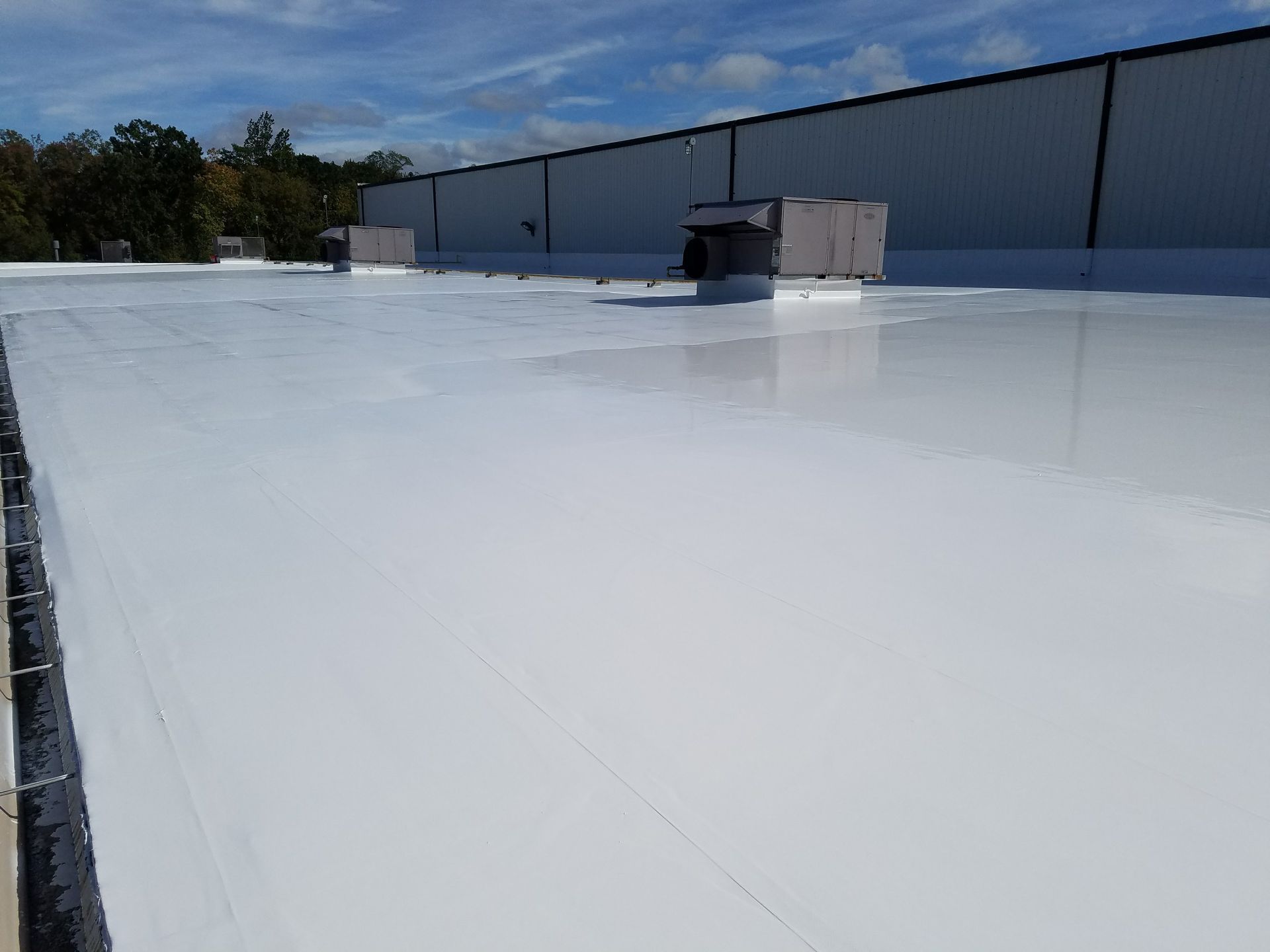 A white roof with a chimney on top of it.