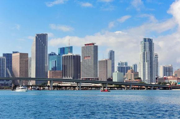 A city skyline with a bridge over a body of water.
