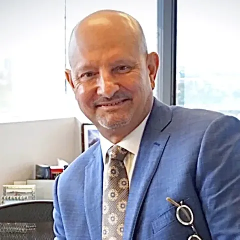 A man in a suit and tie is sitting at a desk.