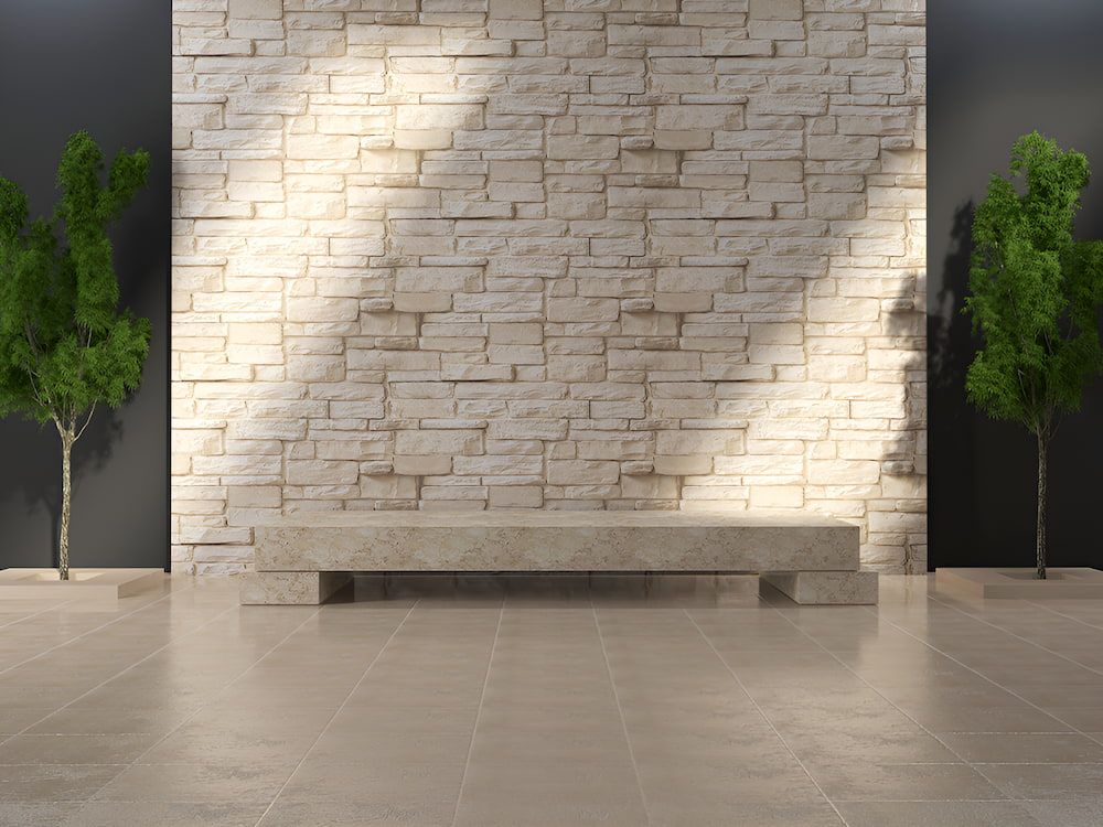 A Brick Granite Wall With A Bench In Front Of It And Two Trees — Stone Theory In Queanbeyan West, NSW