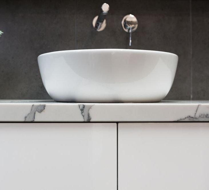 A White Sink Is Sitting On Top Of A Marble Counter In A Bathroom. — Stone Theory In Queanbeyan West, NSW