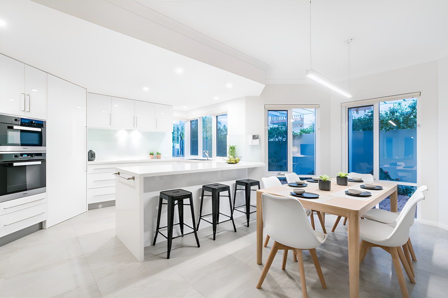 A Newly Installed Kitchen Benchtop And Dining Room In A House With A Table And Chairs — Stone Theory In Queanbeyan West, NSW