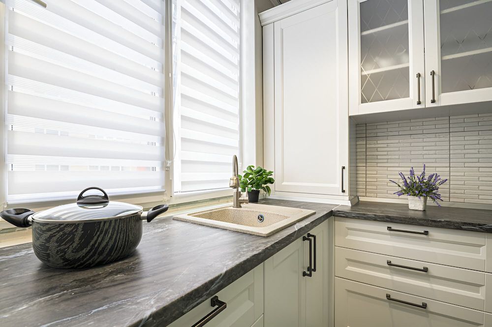 A Marble Kitchen Benchtop With White Cabinets, A Sink, And A Pot On The Counter — Stone Theory In Queanbeyan West, NSW