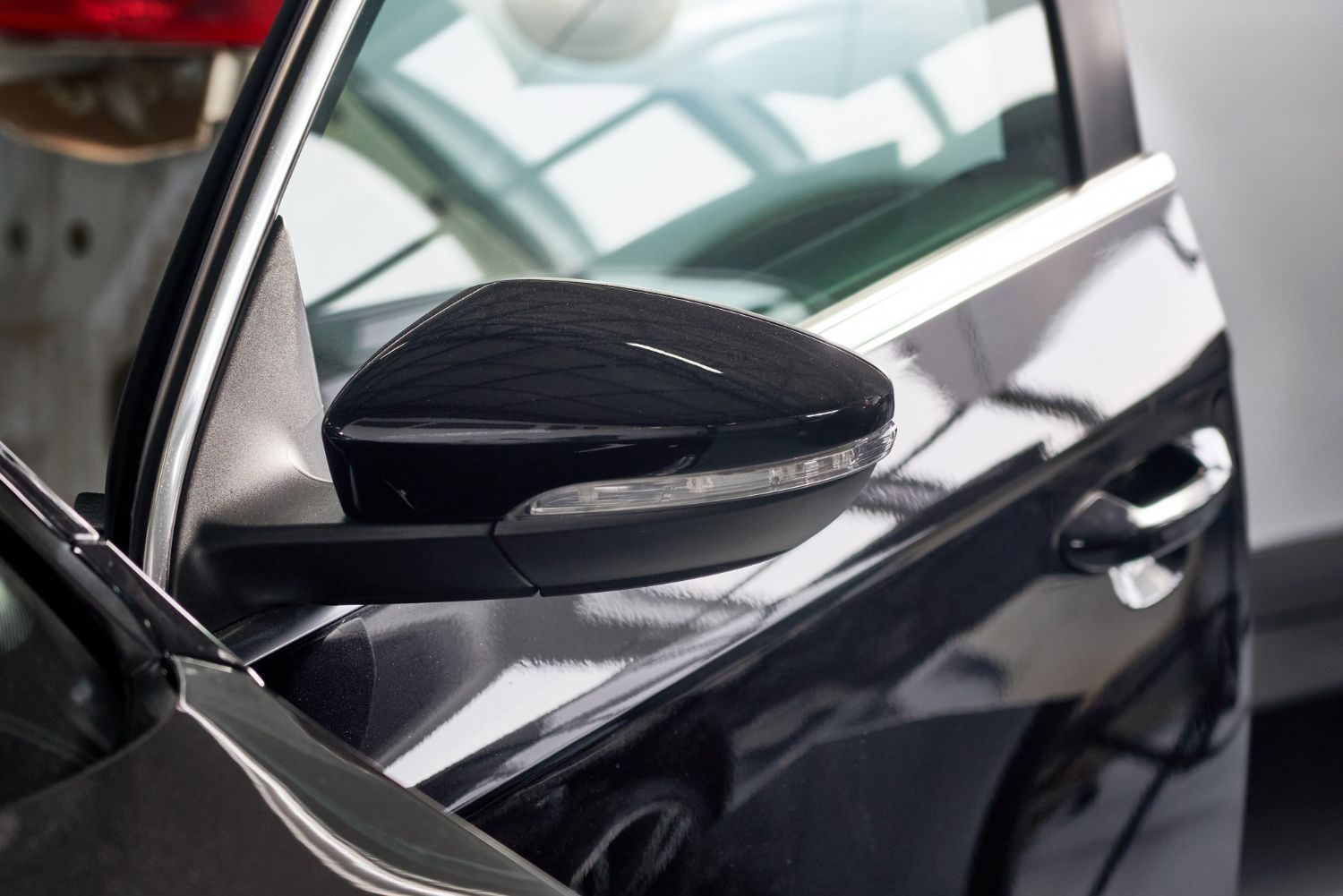 A close up of a side view mirror on a black car