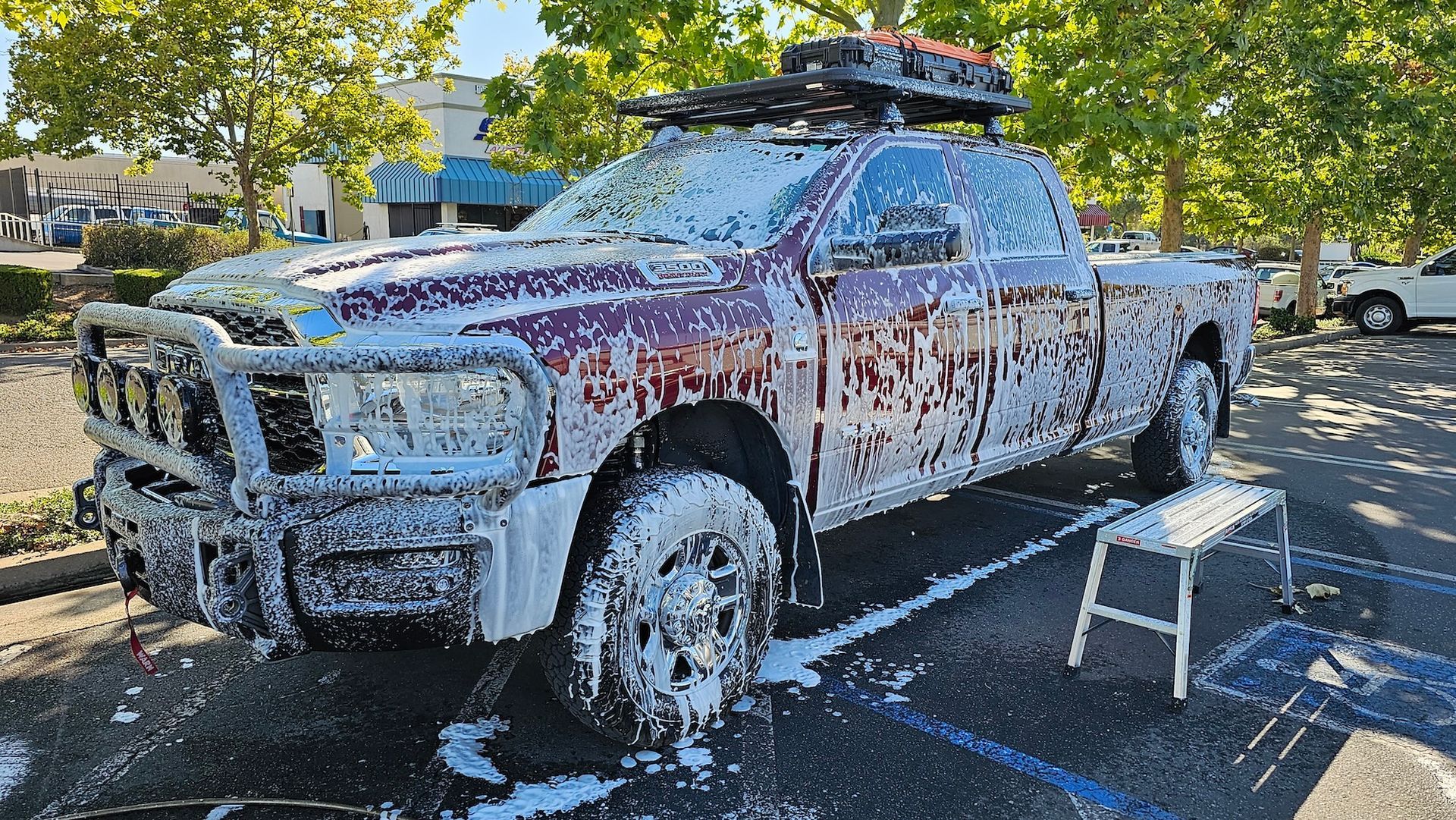 A truck is covered in foam in a parking lot.