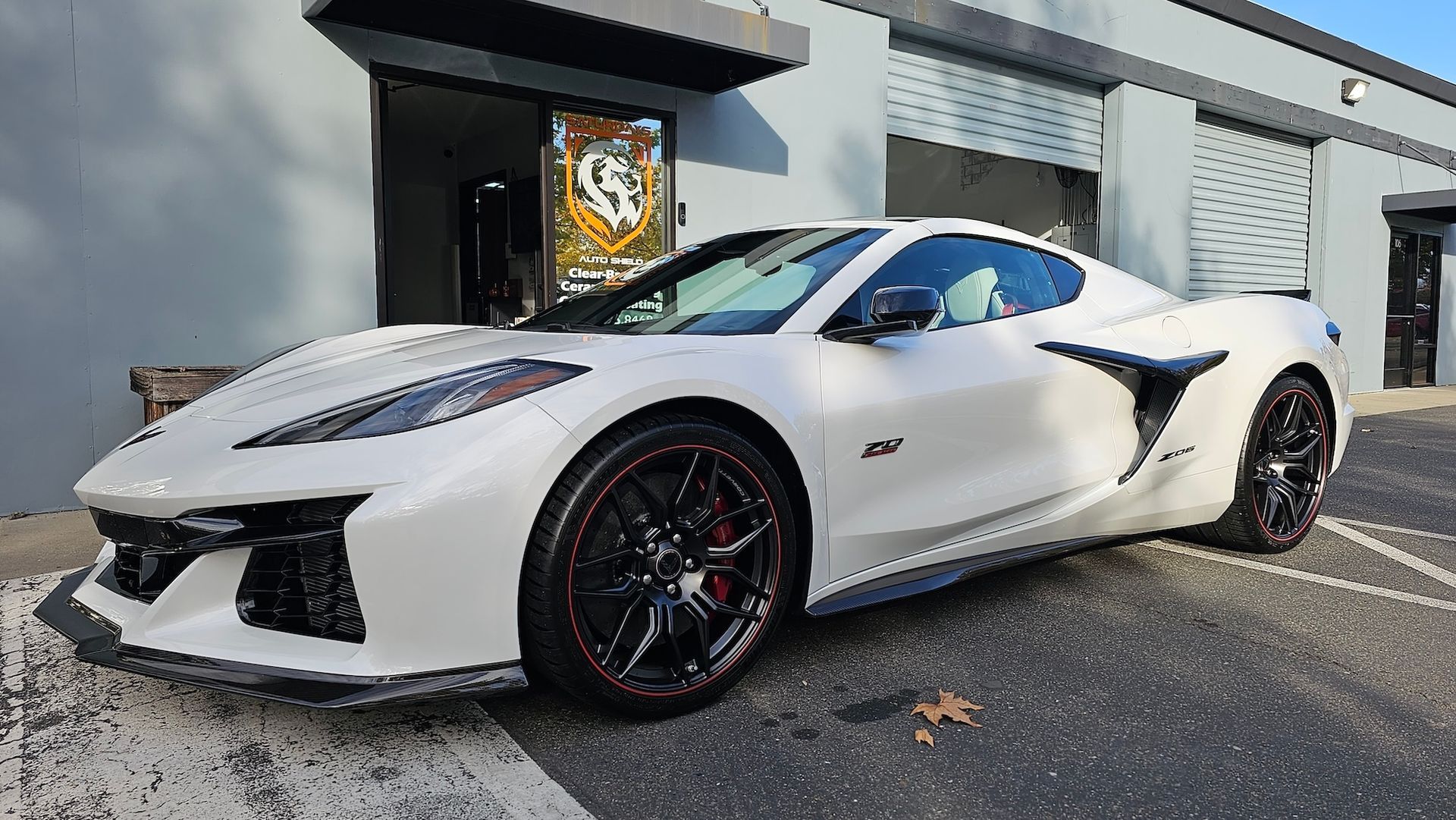 A white sports car is parked in front of a building.