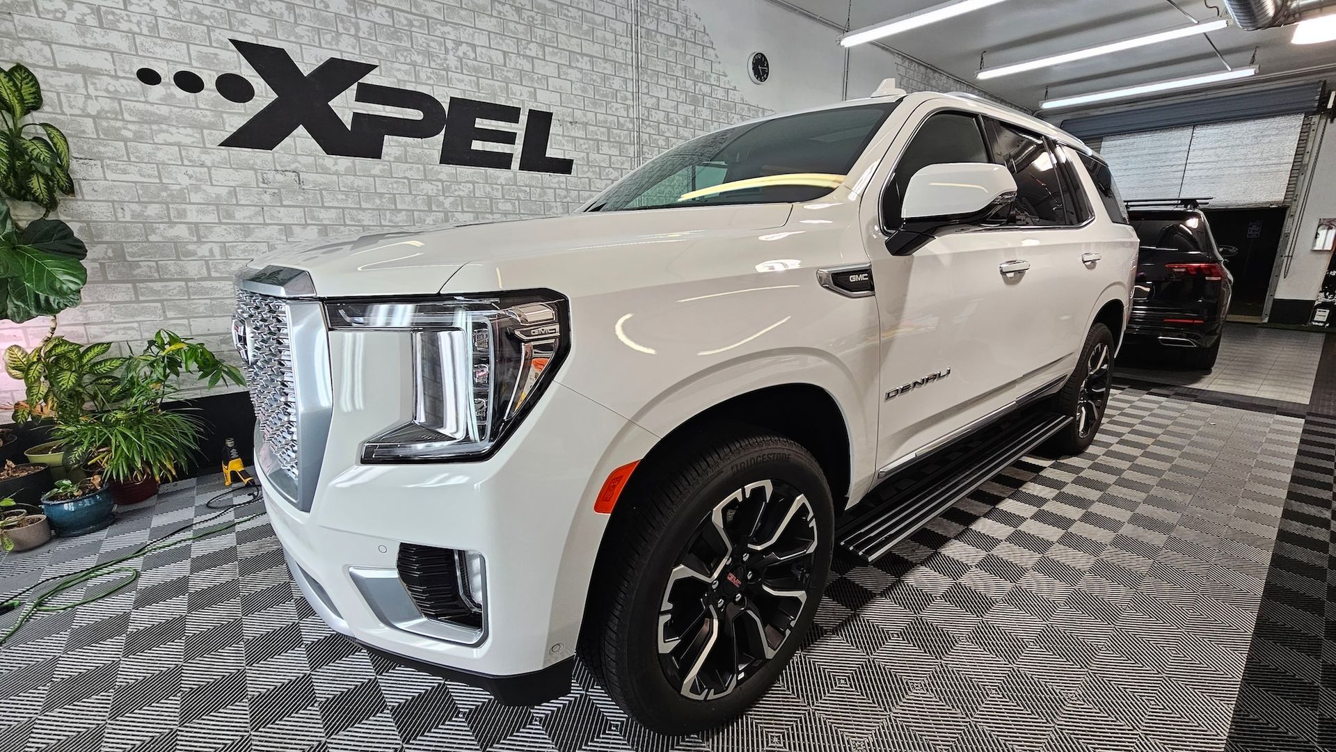 A white gmc yukon is parked in a car wash.