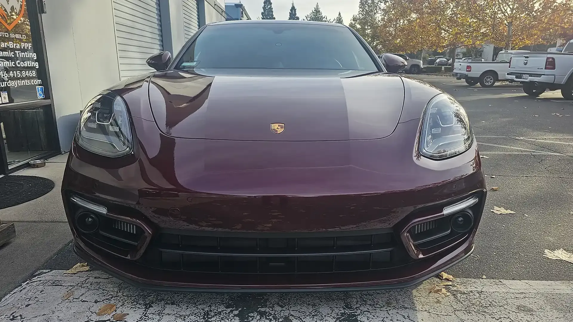 A red porsche panamera is parked in a parking lot.