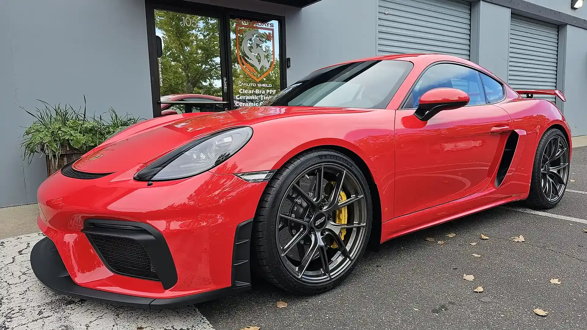 A red sports car is parked in front of a building.