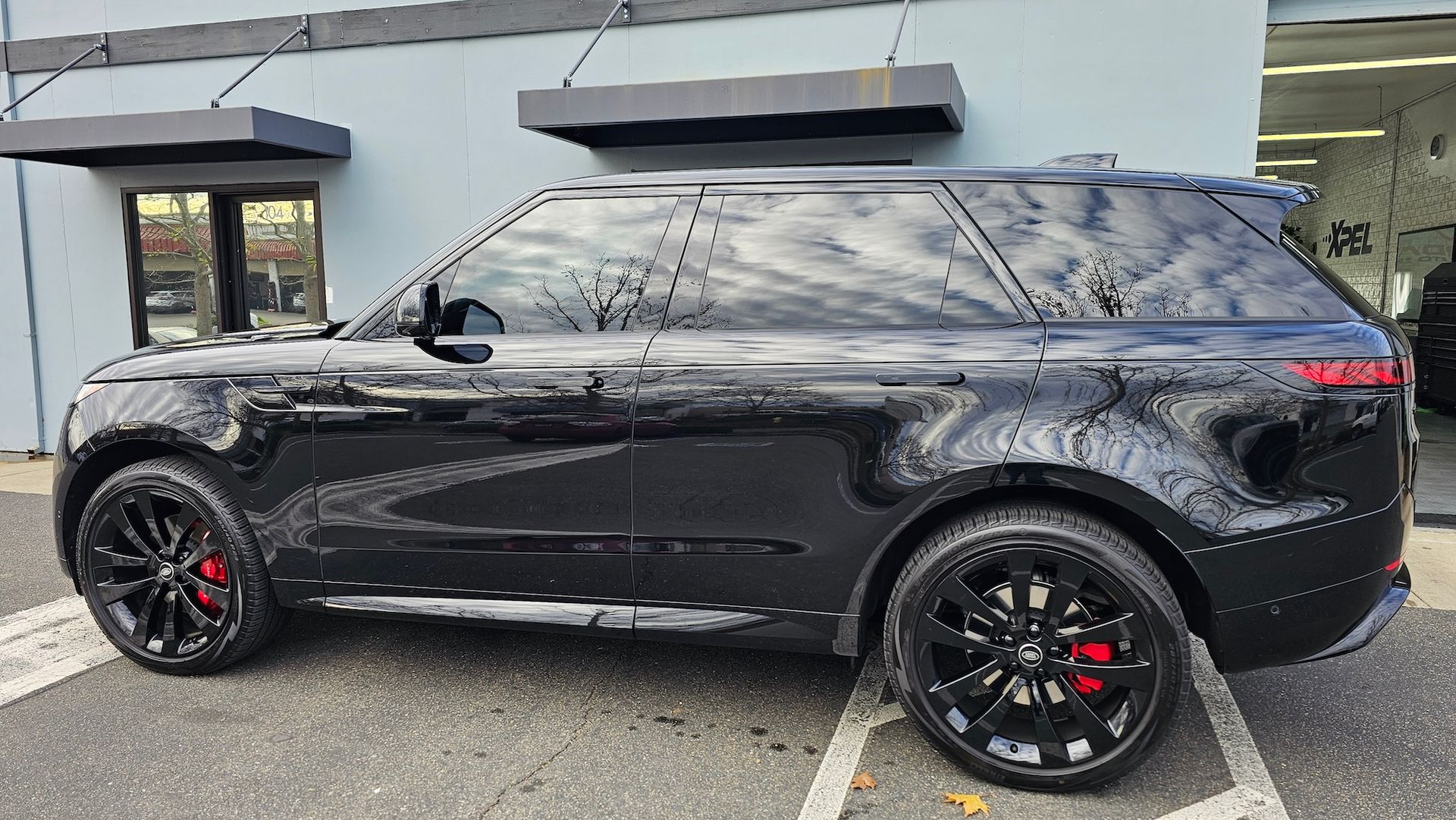 A black range rover sport is parked in front of a building.