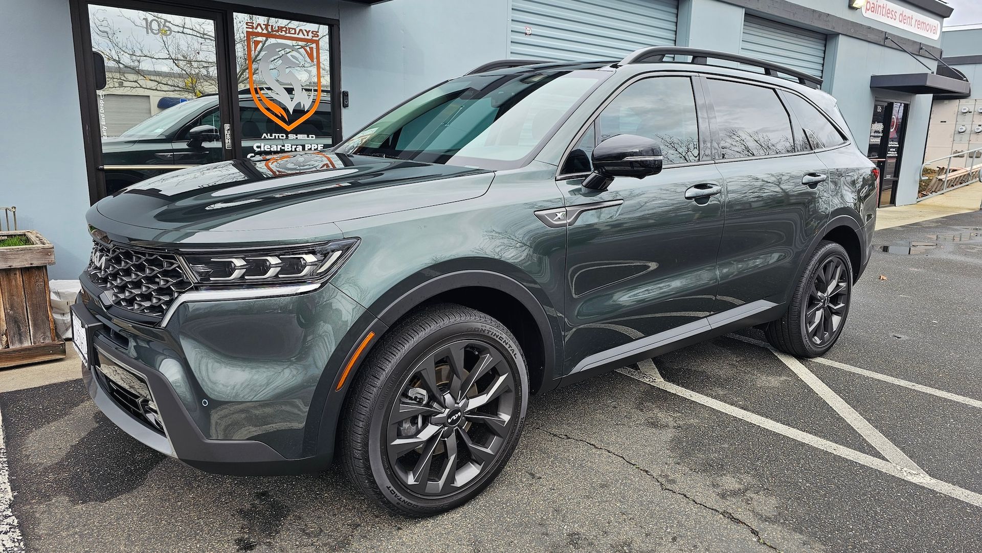 A gray suv is parked in a parking lot in front of a building.