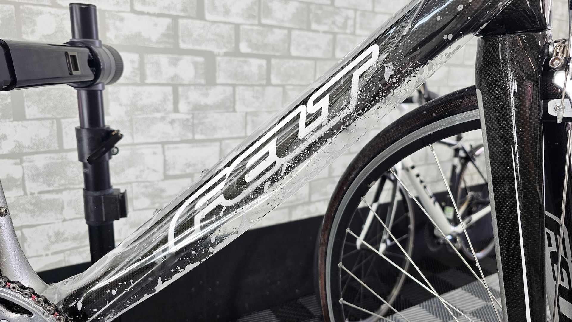 A bicycle is sitting on a stand in front of a brick wall.