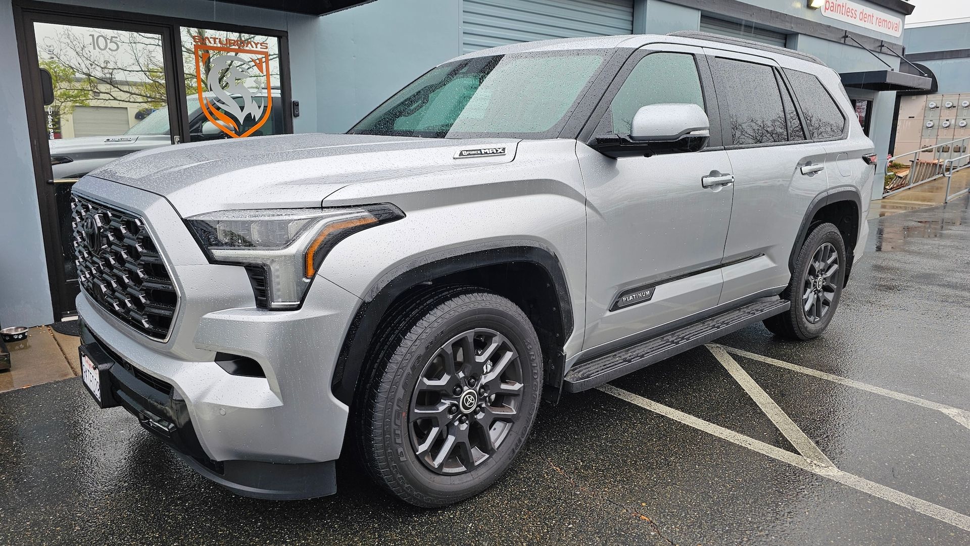A silver toyota tundra is parked in a parking lot in front of a building.