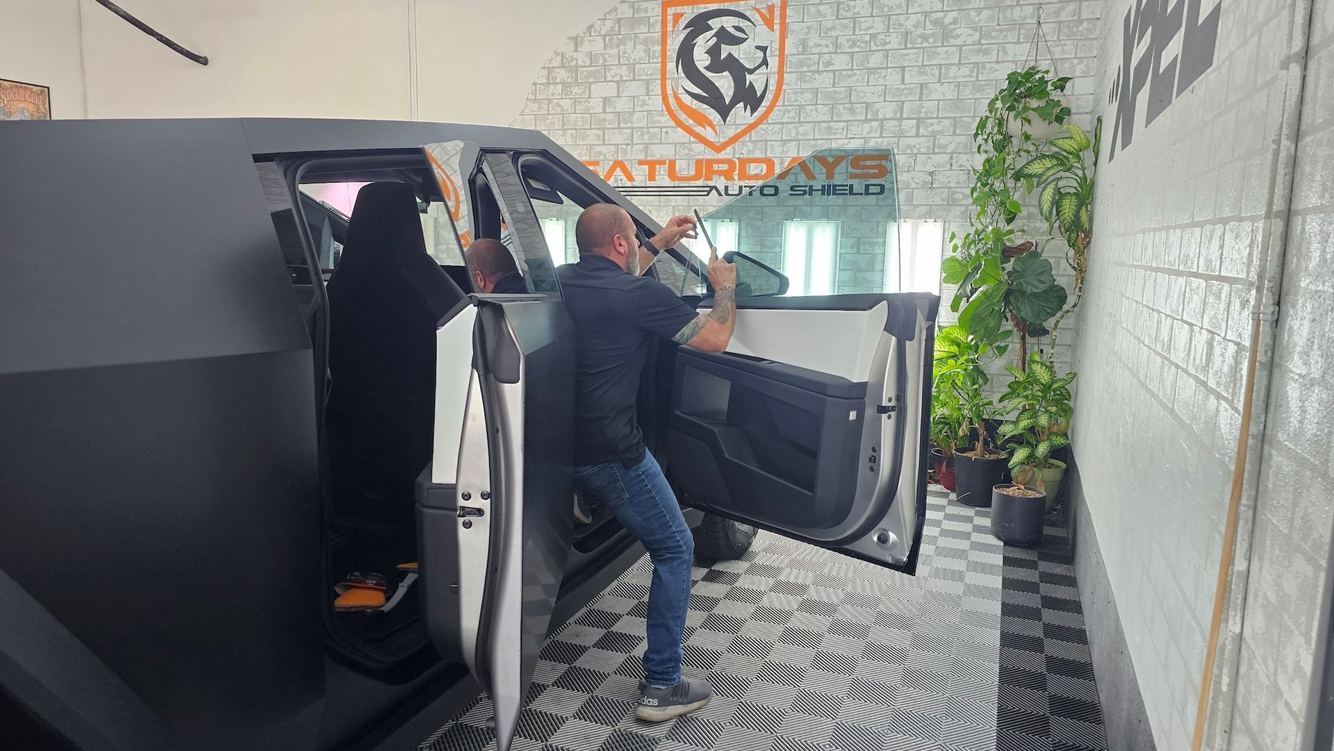 A man is standing next to a car with its doors open.