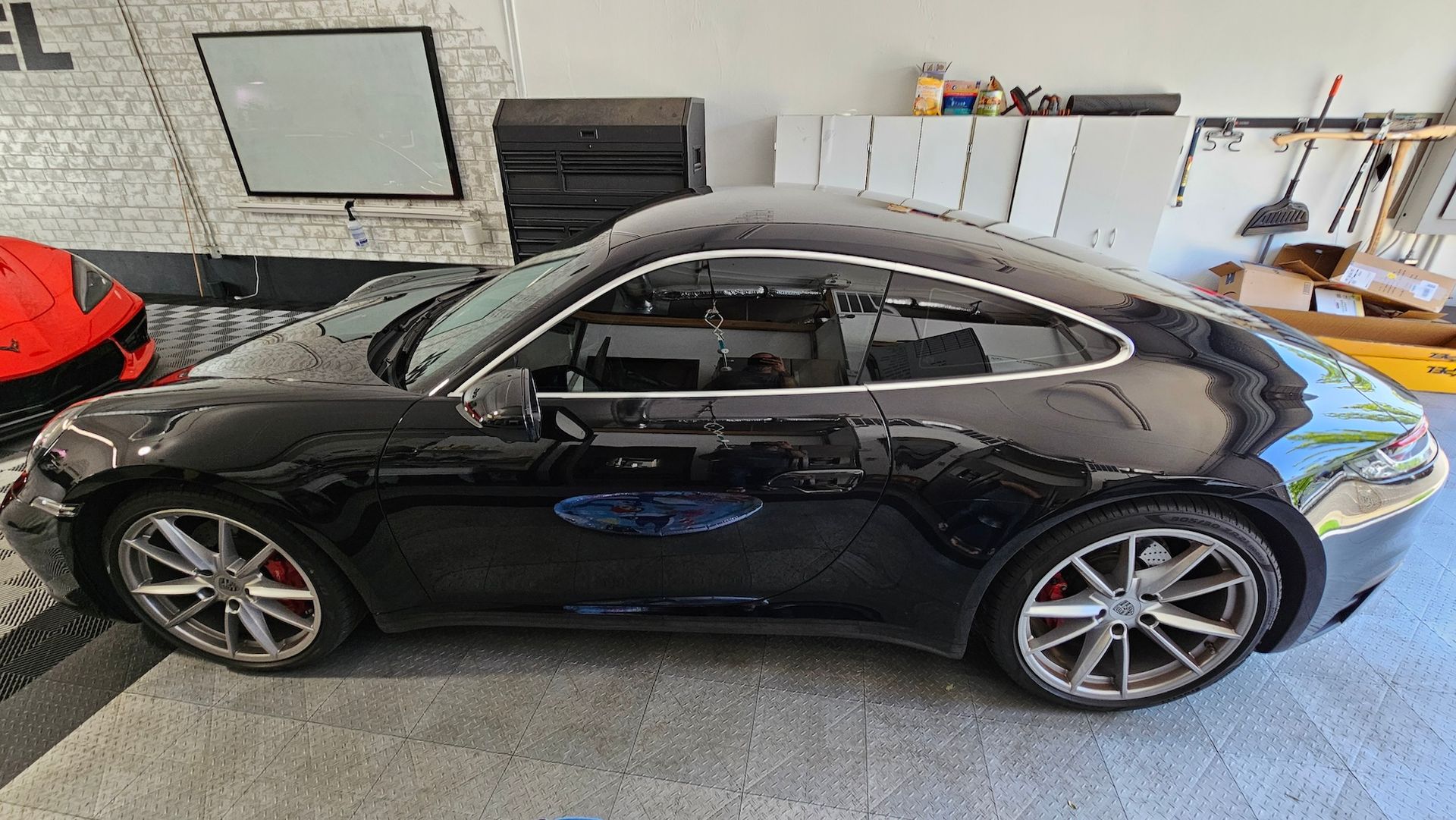 A black porsche 911 is parked in a garage.