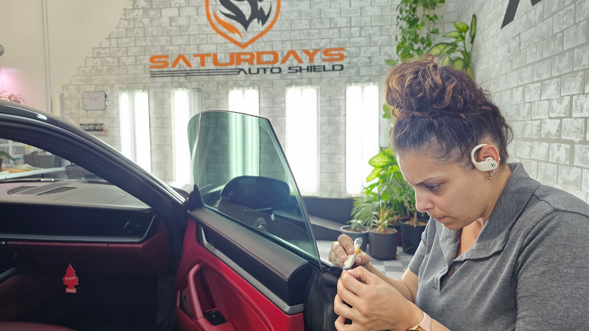 A woman is working on a car in a garage.