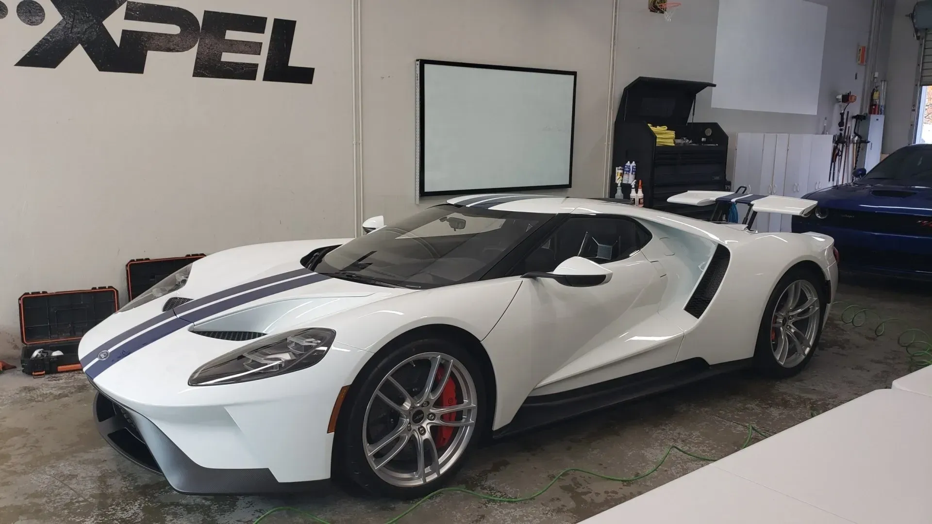 A white ford gt is parked in a garage.