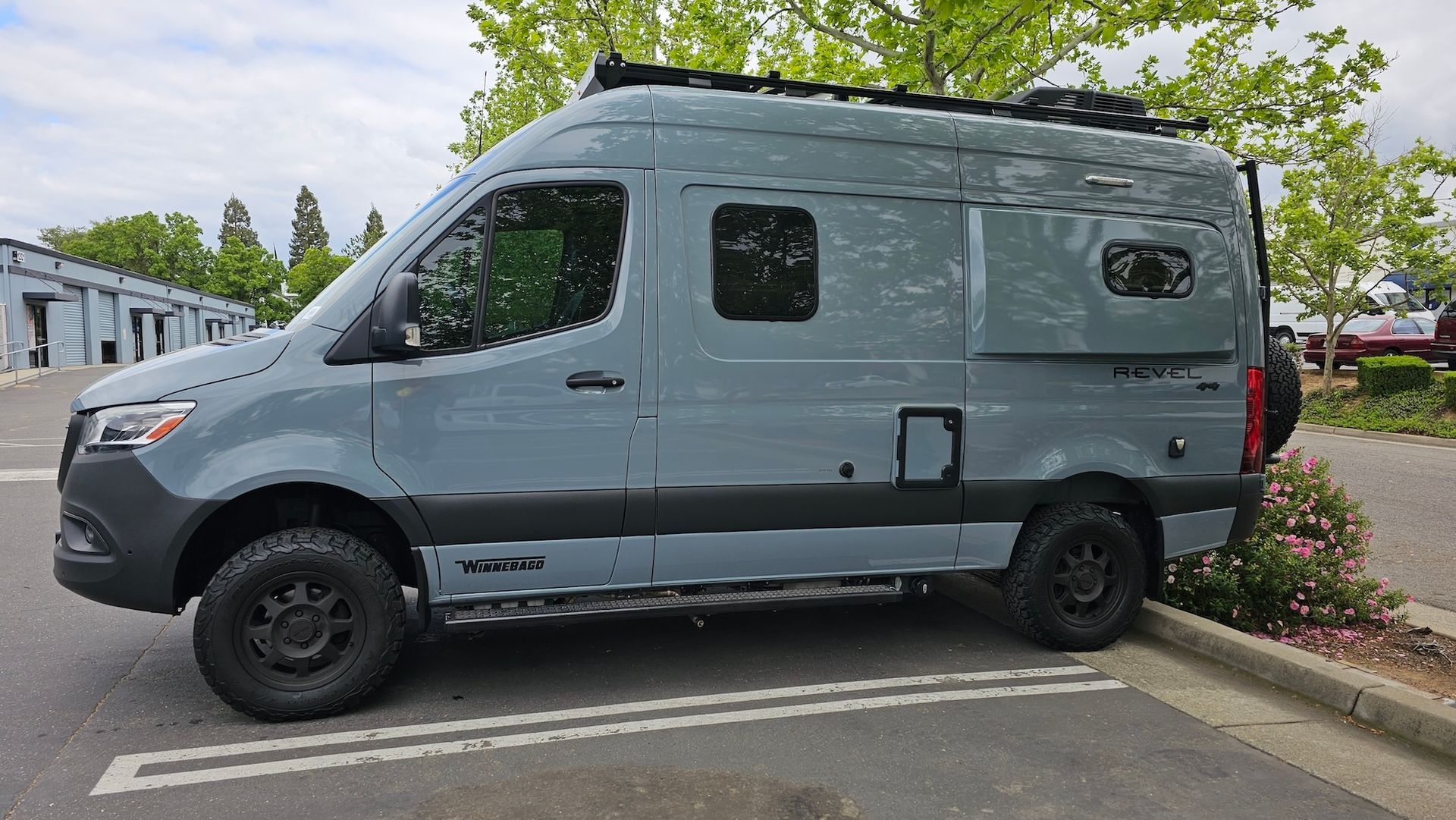 A gray van is parked in a parking lot.