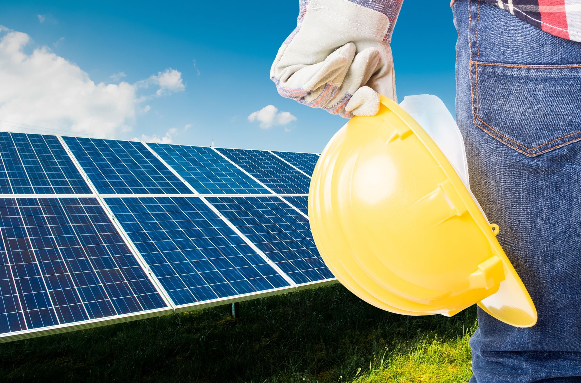 Installatore di pannelli solari su un tetto, indossa dispositivi di sicurezza e lavora sui pannelli solari.