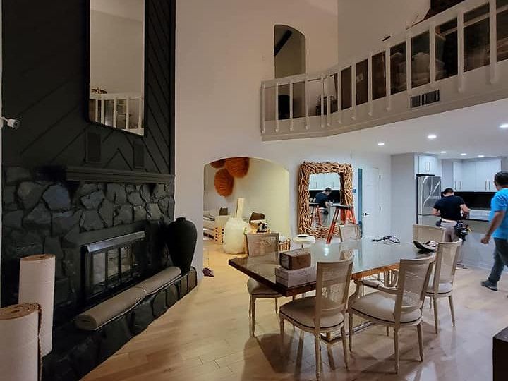 A living room with a fireplace and a table and chairs