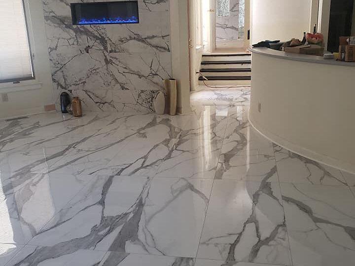 A living room with a marble floor and a fireplace.