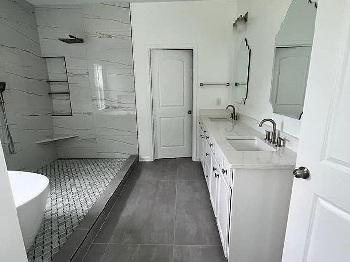 A bathroom with a walk in shower , sink , and mirror.