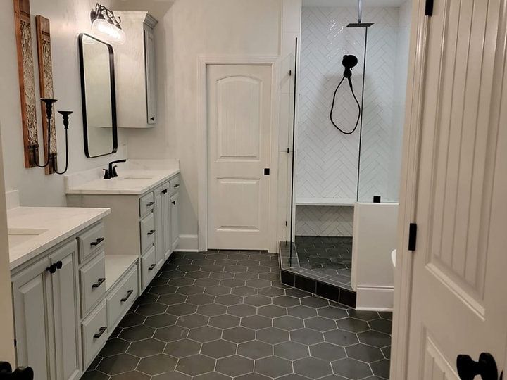 A bathroom with two sinks , a shower and a mirror.