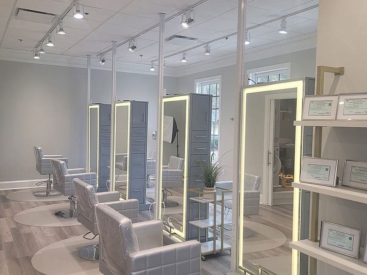 A hair salon with a lot of chairs and mirrors.