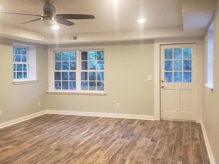 An empty living room with hardwood floors and a ceiling fan.