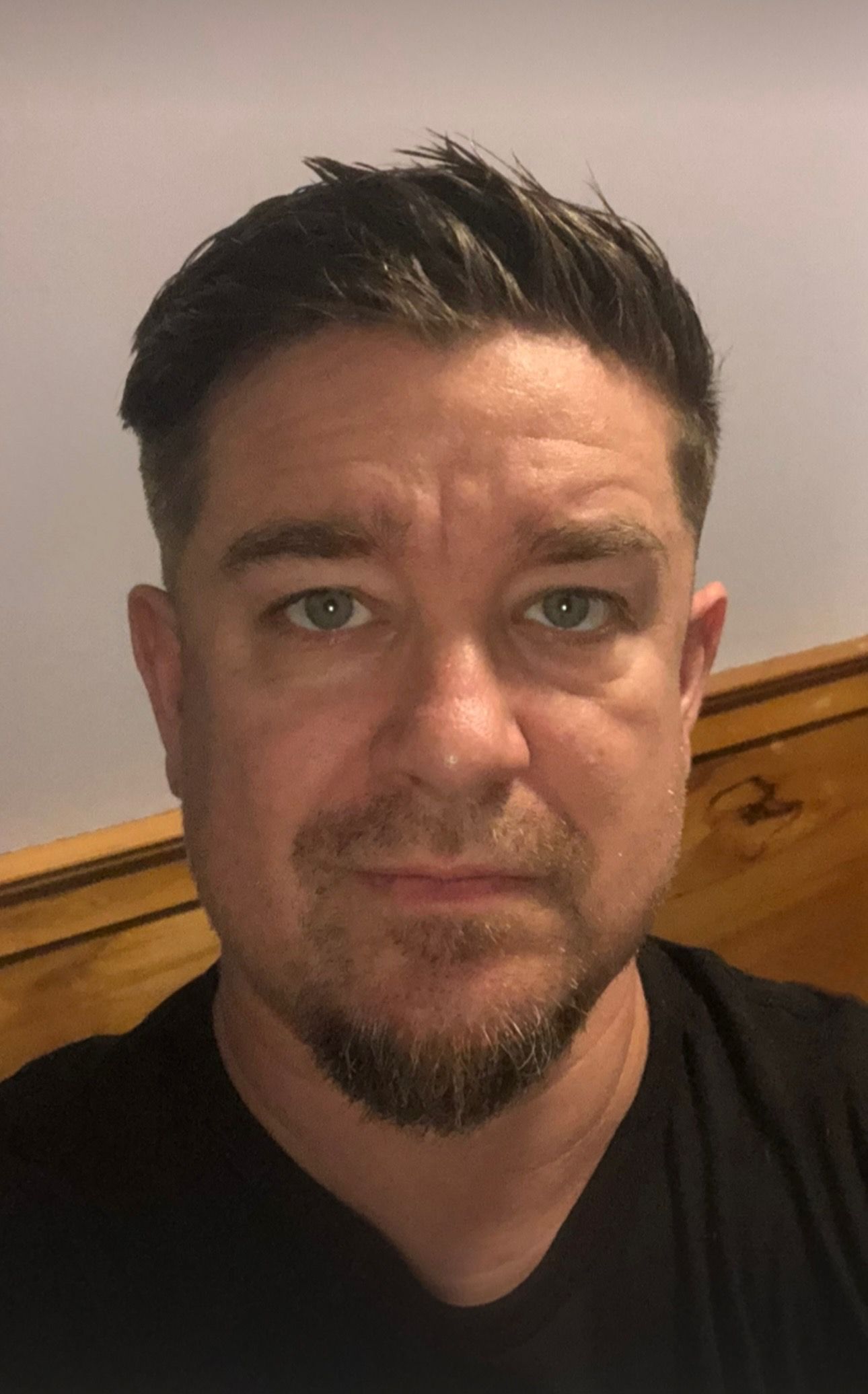 Man with short dark hair and goatee looking directly at the camera, wearing a black shirt.