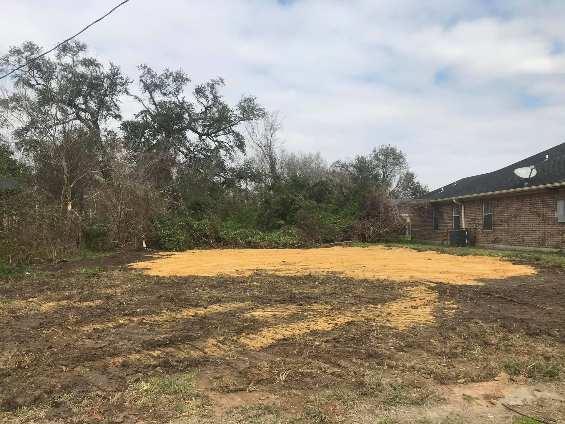 A yellow excavator is sitting on top of a pile of dirt.