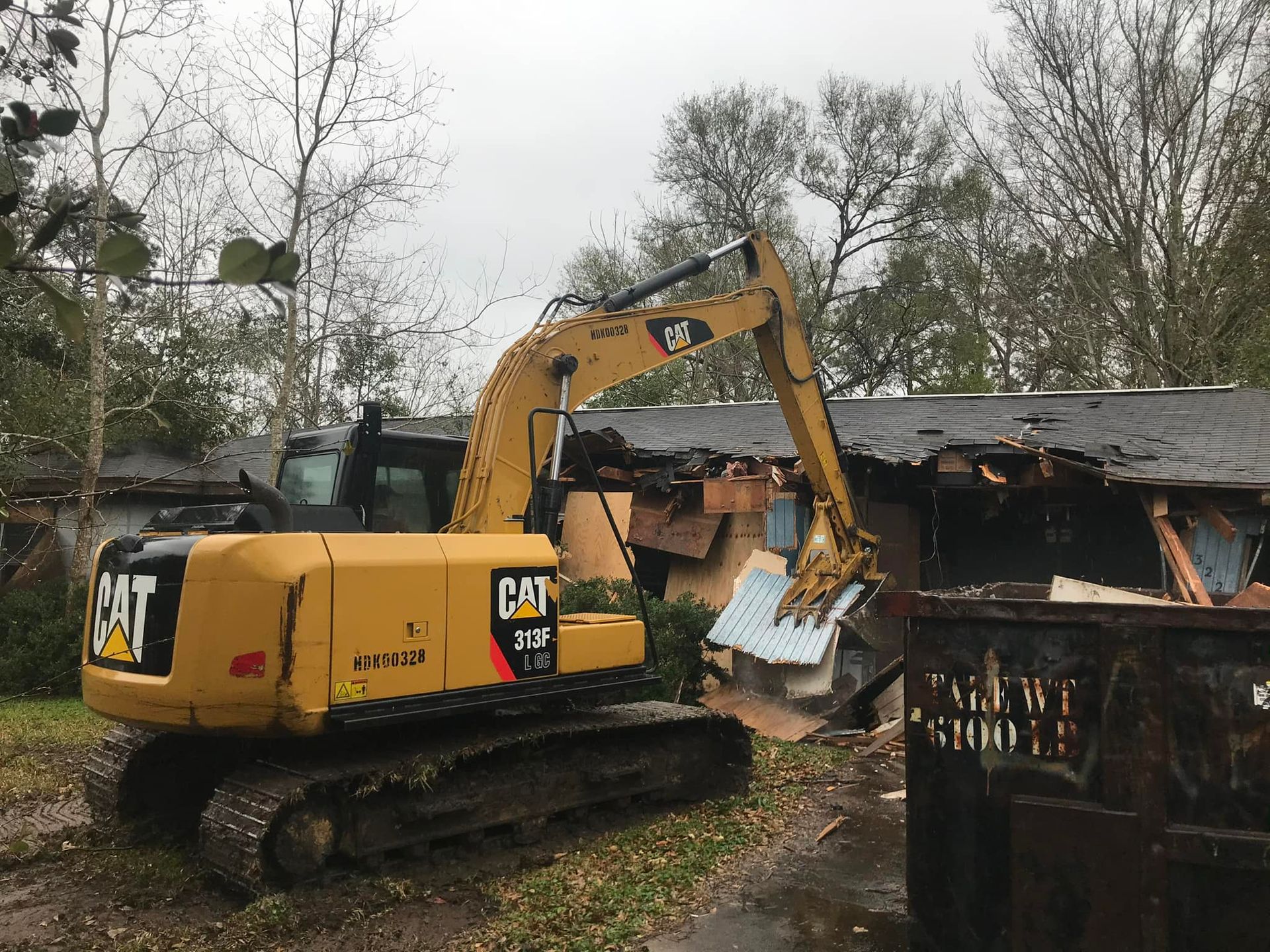 A yellow bulldozer is laying on its side in the dirt.