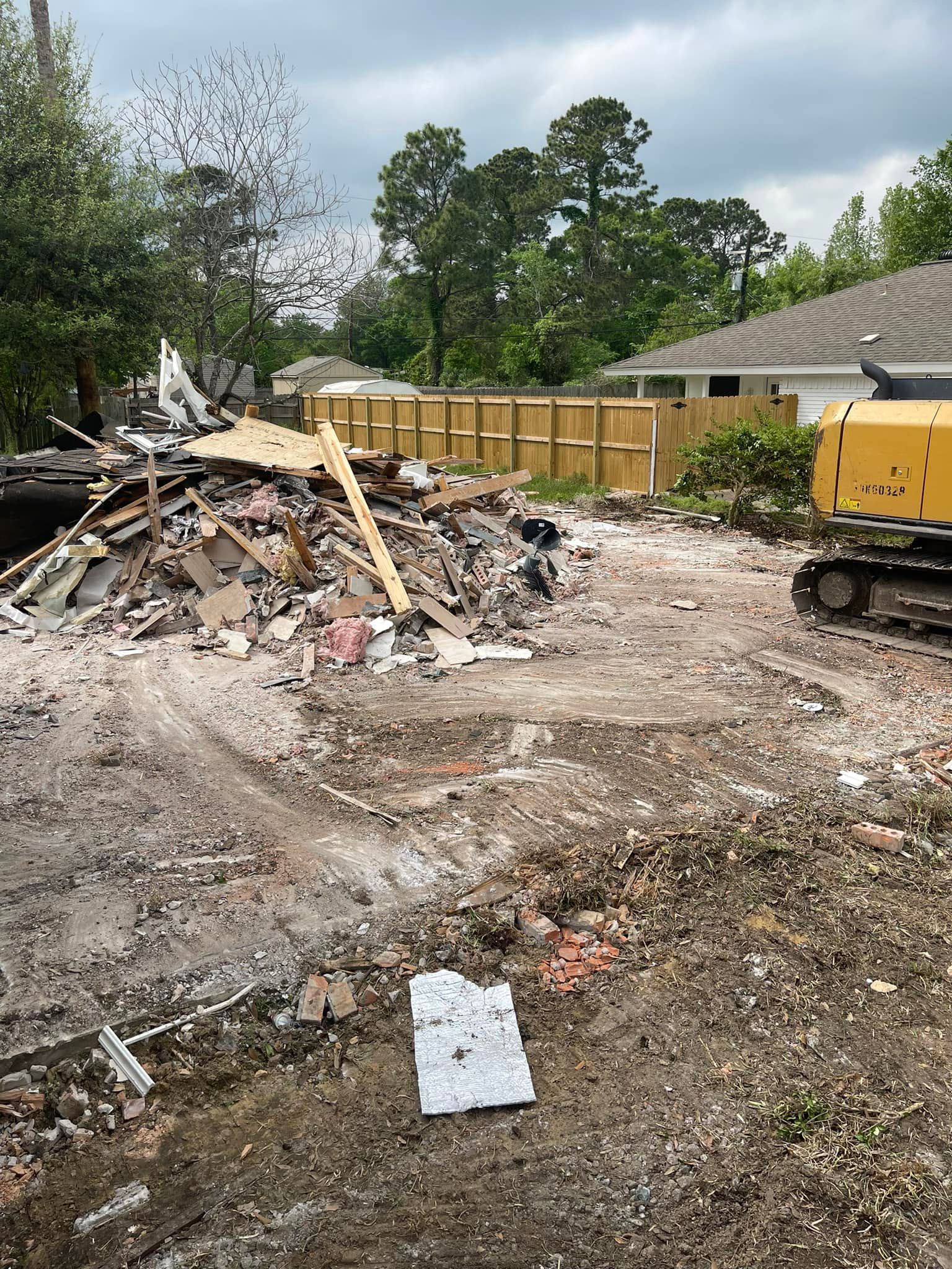 A large pile of rubble is sitting in the middle of a dirt field.
