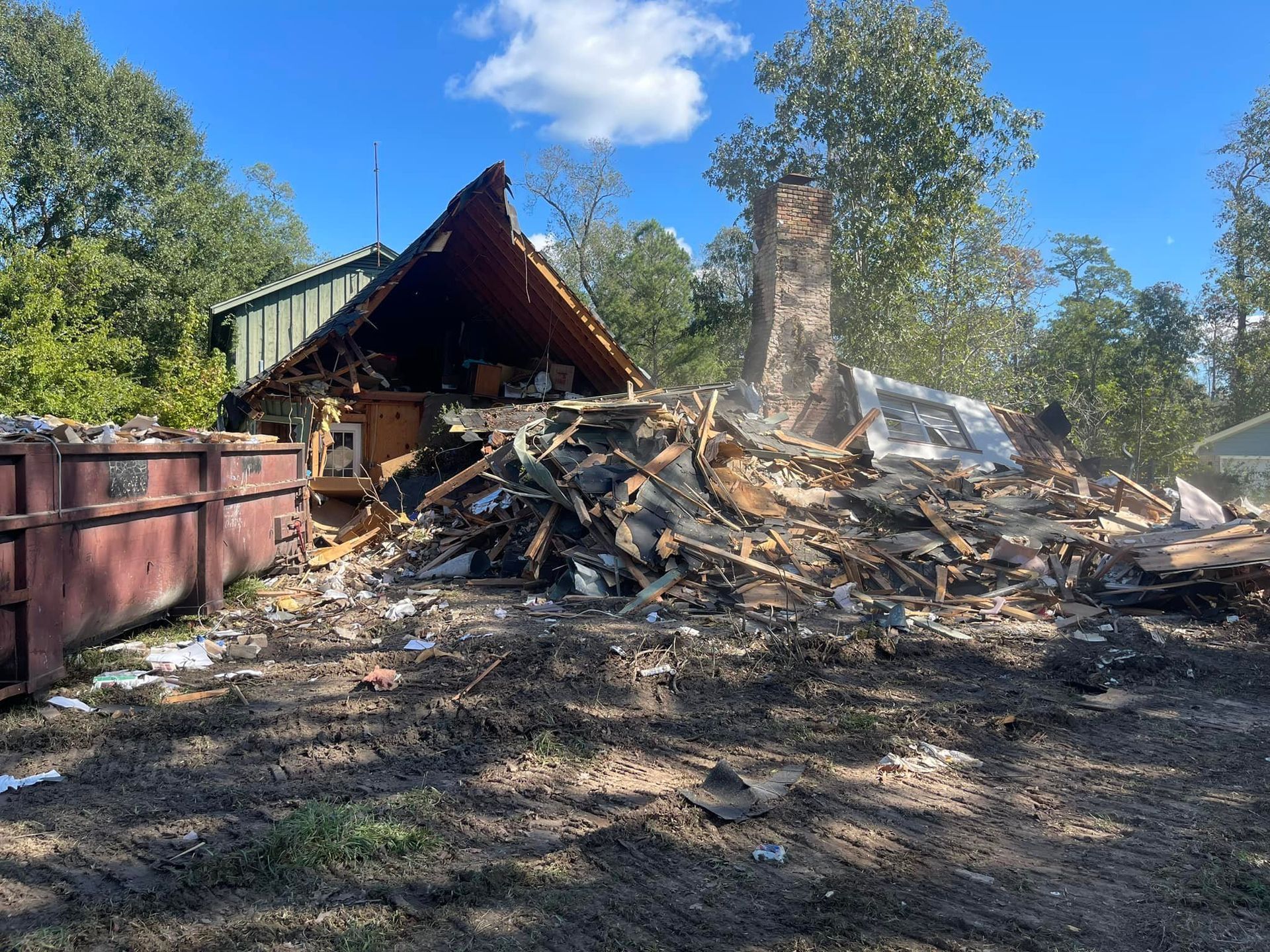 A house is being demolished with a large pile of rubble in front of it.